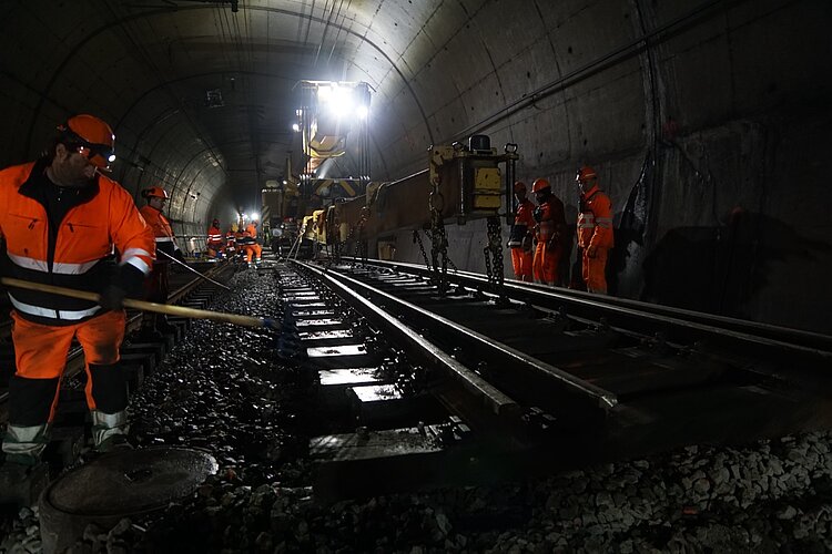 Mit ihren Schottergabeln entfernen die Gleisarbeiter die letzten Steinbrocken von der alten Weiche, bevor sie abtransportiert wird.  
