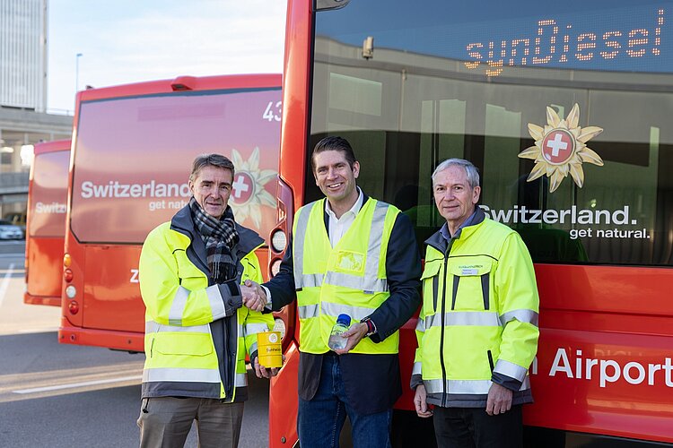 Mit dem erneuerbaren Diesel von Synhelion werden in einem ersten Schritt die Passagierbusse am Flughafen betankt. Von links: Stefan Tschudin, Chief Operation Officer der Flughafen Zürich AG, Philipp Furler, CEO und Mitgründer von Synhelion, Emanuel Fleuti, Leiter Nachhaltigkeit und Umwelt der Flughafen Zürich AG, vor einem solchen Bus.